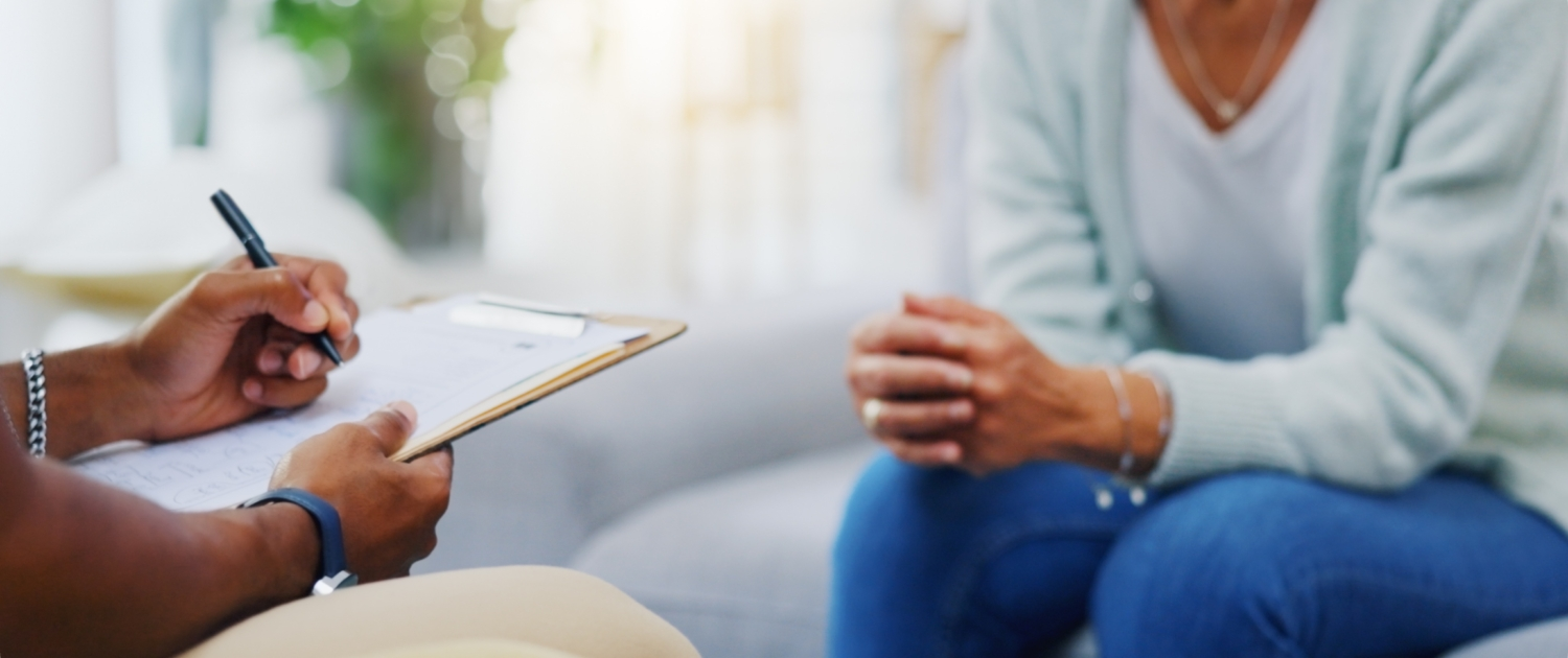 A therapist reviewing notes on a clipboard in a clinical setting